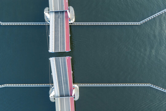 Aerial view of Sobieszewo drawbridge from directly above, spanning the Martwa Wisla River in Gdansk, Poland, showing modern road infrastructure and symmetrical bridge construction.