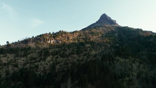 Nevado de Colima (Zapotepetl) volcanic summit above forested mountain slopes in Nevado de Colima National Park, Jalisco, Mexico. Forward aerial shot.