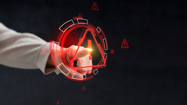 Businesswoman pointing at a glowing red warning triangle icon on a digital interface, symbolizing cybersecurity alert, system error, or risk management on a dark background. Cyber threat concept