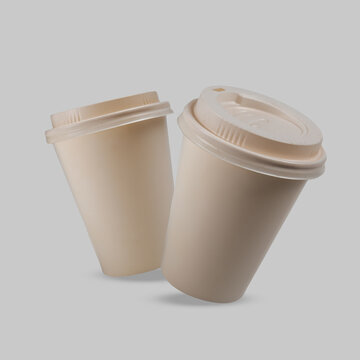 Two beige disposable paper coffee cups with lids floating against a solid light gray background, perfect for branding mockup. Mockup or Copyspace