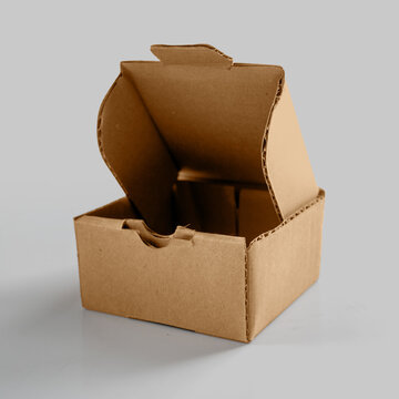 An open brown corrugated cardboard box on a light grey background, perfect for e-commerce, shipping, and packaging mockup concepts. Mockup or Copyspace