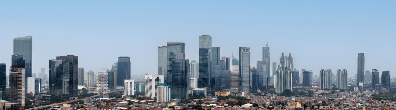 Panoramic view of the modern Jakarta city skyline with skyscrapers and urban residential areas under a clear sky. Jakarta, Indonesia. Cityscapes background