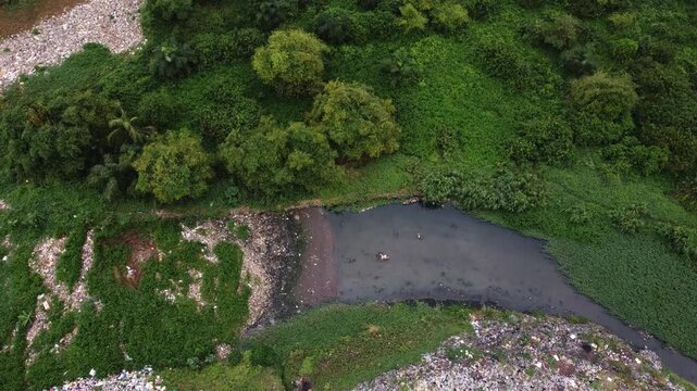 Aerial view of a waste landfill situated along a dense vegetation in the urban landscape of Ogun State, Nigeria. 