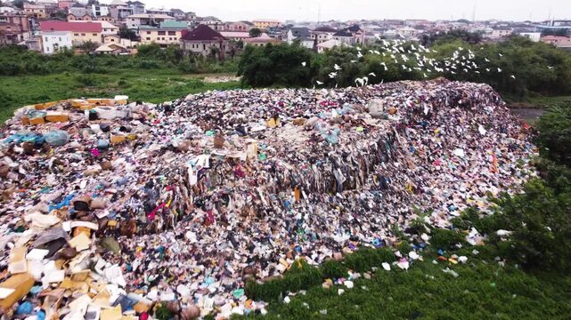 Aerial view of a large waste landfill situated along a dense vegetation in the urban landscape of Ogun State, Nigeria. 