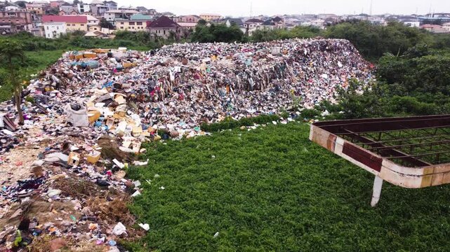 Aerial view of a large waste landfill situated along a dense vegetation in the urban landscape of Ogun State, Nigeria. 