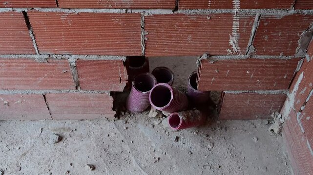 Electrical conduit pipes in a brick wall at construction site