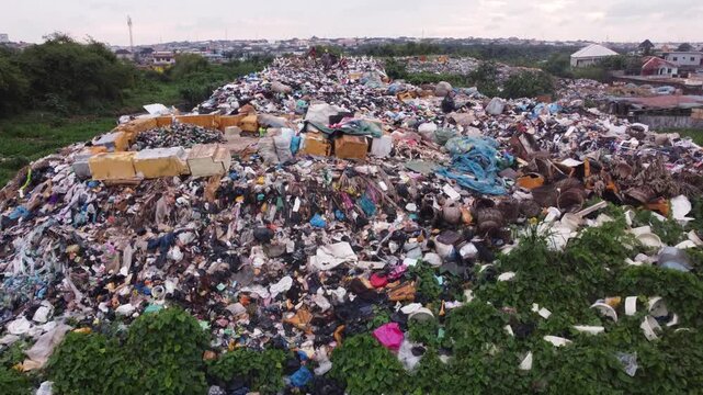 Aerial view of a large waste landfill situated along a dense vegetation in the urban landscape of Ogun State, Nigeria. 