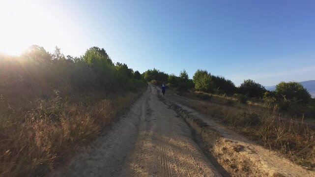 Trail running woman with determined focus tracking shot along rural dirt path