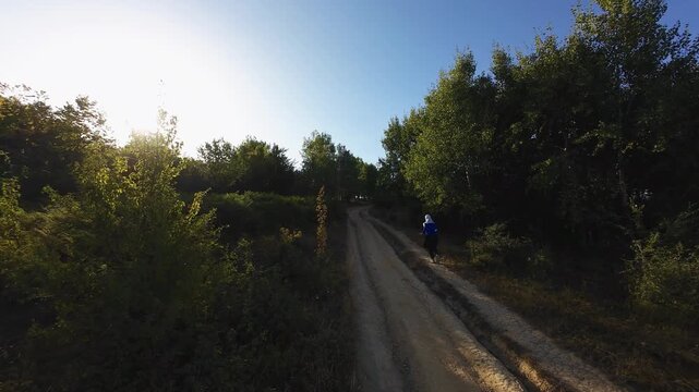 Trail running woman determined solitude golden hour tracking shot