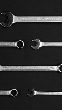 Wrenches and spanners arranged in rows on black background. Professional mechanical tools for construction maintenance and repair work