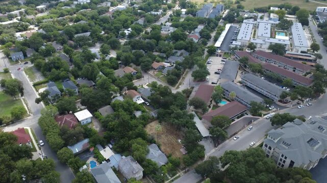 Quiet neighborhood avenues crisscross Mahncke Park in South Texas near Broadway. Sprawling tree canopy conceals detached cottages, apartment complexes, swimming pools, paved roads, San Antonio