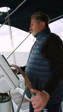 Experienced male skipper navigating sailboat at sea