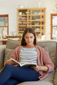 Home, woman and relax with book on sofa for reading hobby, story chapter or self improvement. Reader, peaceful person and fantasy novel in apartment for bestseller release, knowledge or weekend break