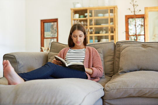 Relax, woman and reading a book in home for literature hobby, knowledge or fantasy story on weekend. Reader, calm person and literary novel on sofa for fiction bestseller, vocabulary or holiday break