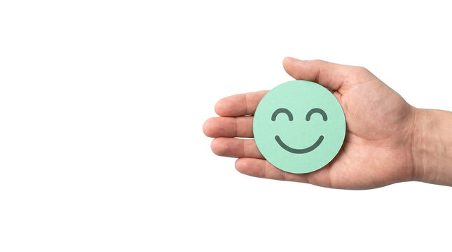 Hand holding green smiley face transparent PNG, isolated happy feedback symbol cutout for wellness and satisfaction design