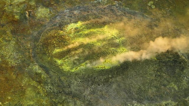 Aerial view of the vibrant yellow and green mineral deposits and rising steam at the Dalol geothermal area in Dalol, Afar, Ethiopia.