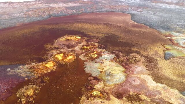 Aerial view of the vibrant and colorful geothermal pools and salt formations at the Dalol geothermal area in Dalol, Afar, Ethiopia.
