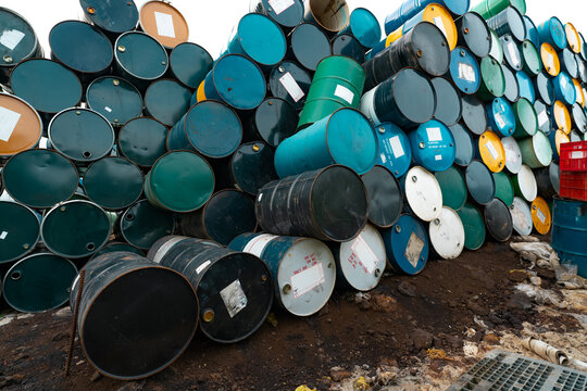 Old chemical barrels. Hazard chemical barrel with warning label. Blue, green, yellow and black oil drum. Steel oil tank. Toxic waste warehouse. Hazard waste storage in factory. Lubricant oil drum.