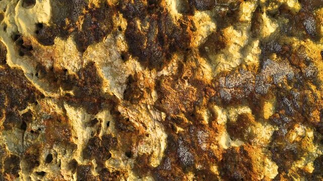 Aerial view of the vibrant mineral deposits and rugged textured surface of the geothermal area in Dalol, Afar, Ethiopia.