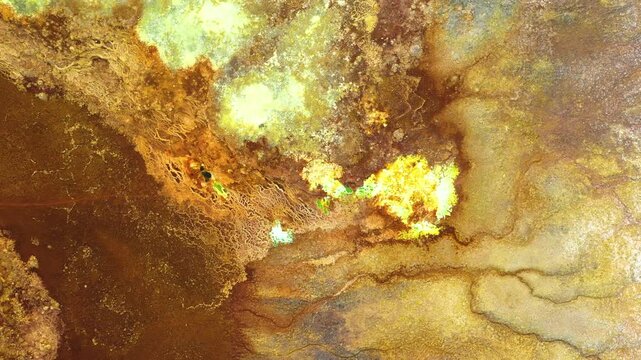 Aerial view of vibrant yellow and brown mineral deposits and hydrothermal activity in the geothermal area of Dalol, Afar, Ethiopia.