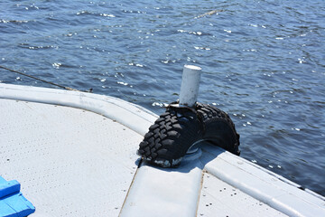 Tire Fender Attached to Boat Bow on Water, protection, copy space © Irina
