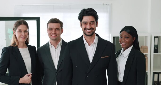 Portrait of Middle Eastern leader with professional team stands in company office. Business organization staff supports racial tolerance in corporate setting