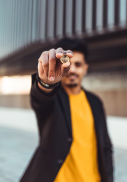 Moroccan man holding a euro coin, presenting money and currency for financial investment, wealth, and economy
