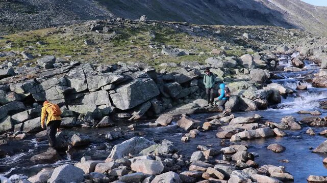 Beautiful european family with children and pet dog, hiking Kyrkja mountain on a beautiful sunny summer day, sunset, snow, lakes, valley