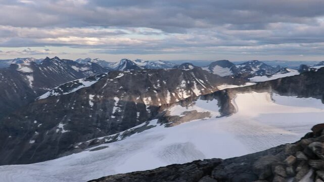 Beautiful european family with children and pet dog, hiking Galdhoppigen, 2469 m, the highest mountain peak in Norway on a beautiful sunny summer day, sunset, snow