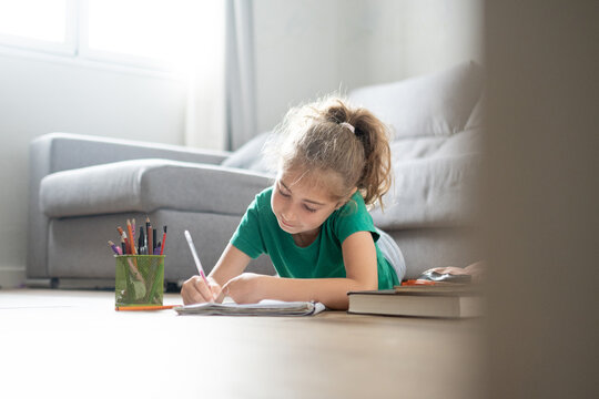 Happy girl doing homework at home