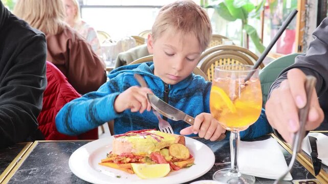 Preschool child, cute boy, eating fish with vegetables in a restaurant, cozy atmosphere, local restaurant in Oslo, Norway
