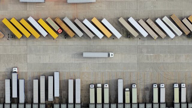 Overhead Drone Shot of Articulated Lorries Parked in Symmetrical Depot Bays
