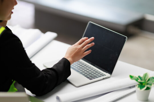 Professional woman working on a laptop, using modern technology for business communication, analyzing data, and collaborating on projects in an office environment