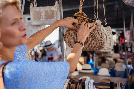 Close Up of Mature Woman Examining Handmade Crochet Handbag at Spanish Outdoor Market