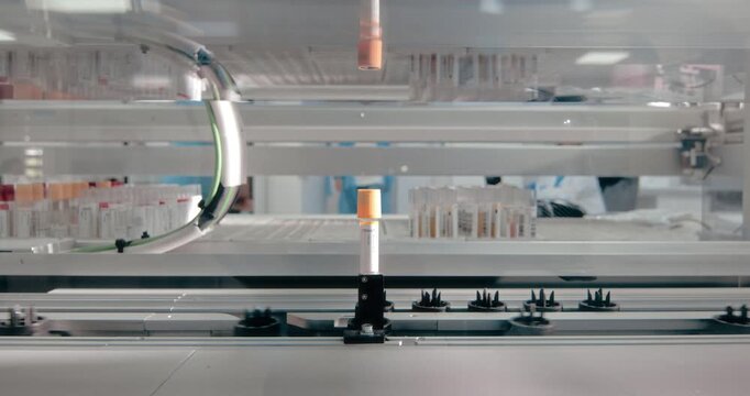 Robotic laboratory equipment automatically handling colored sample tubes during a clinical testing process.