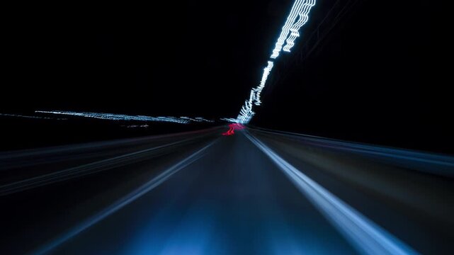 Nighttime Drive Through Illuminated Road Lights With Motion Blur Effects. Hyperlapse Road Trip. Driving Along a Highway at Night Featuring Bright Streetlights Overhead and Motion Blur Effects.