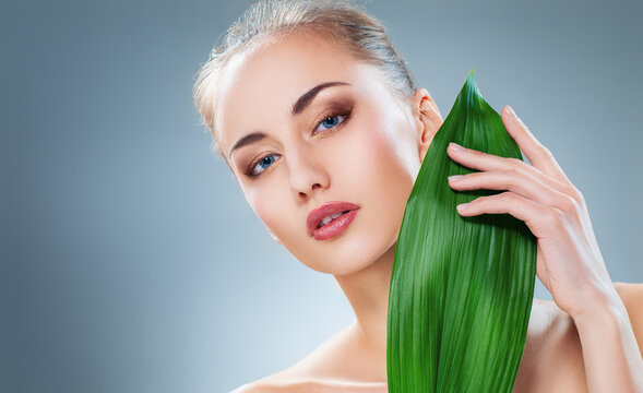 Natural Beauty Skincare Concept with Young Woman and Green Leaf Against Clean Background