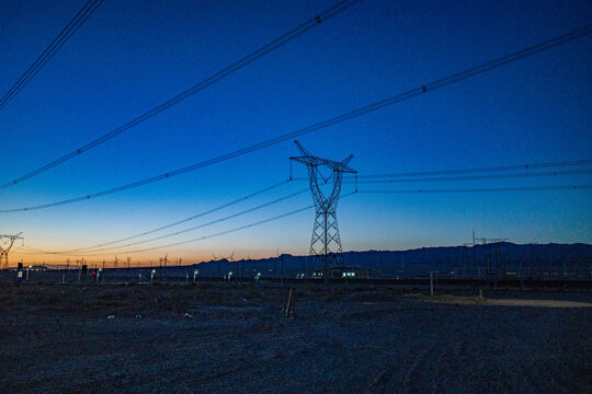 High-voltage power transmission tower at dusk