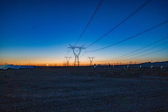High-voltage power transmission tower at dusk