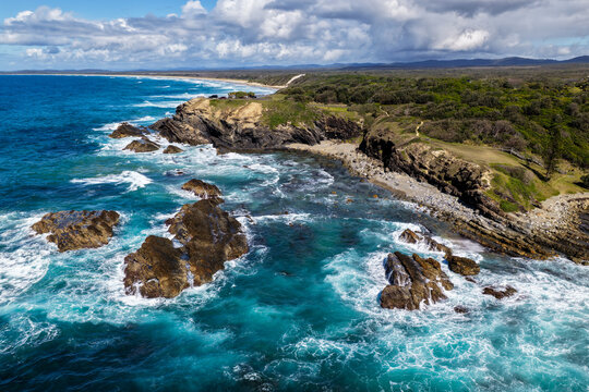 Aerial view of clear turquoise ocean water and rugged rocky coastline at Brooms Head, showcasing the natural coastal landscape and distinctive rock formations along the Clarence Valley coastline