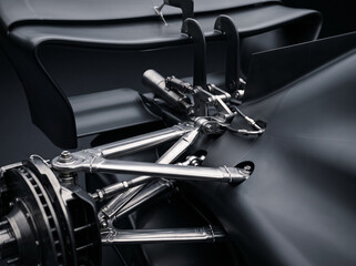 Fototapeta premium close up detail shot of sports racing car front wheel suspension wishbones brake disc assembly and carbon fiber elements displaying high performance engineering components and layout