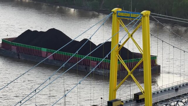 Coal barge transporting cargo under Barito Bridge in South Kalimantan, Indonesia