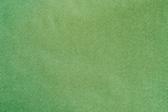 Full frame top view of flat light green cotton twill fabric texture with diagonal weave pattern horizontal stock photo