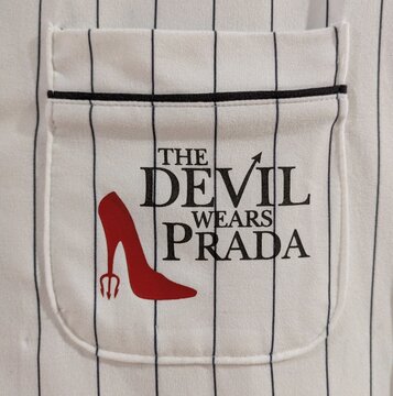 Vista de cerca del estampado del nombre de la pel&iacute;cula The Devil Wears Prada con su logo, en el bolsillo de una camisa. Madrid, Espa&ntilde;a, 14 de junio de 2026	