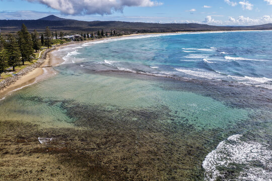 Aerial view of the rockpool and surrounding coastline at Brooms Head, featuring clear ocean water, rugged rock formations and the natural coastal landscape along the Clarence Valley coast