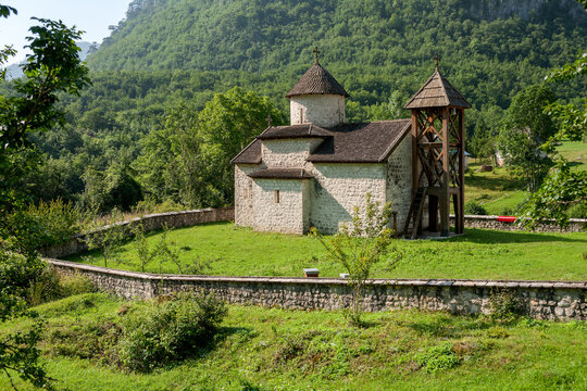 Dobrilovina, Opstina Mojkovac, Montenegro - 29 July 2005: View of Dobrilovina Monastery, a historic stone church with a wooden roof and bell tower, set within a walled courtyard.