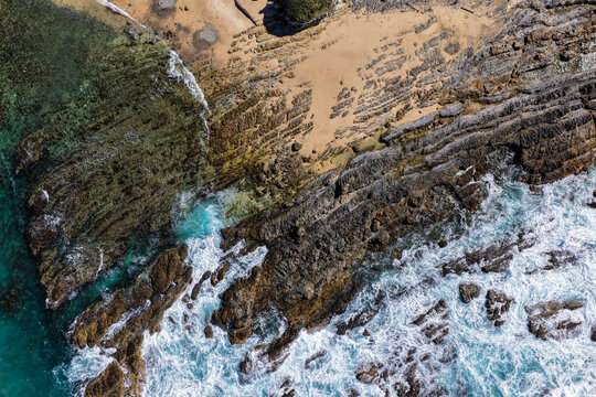 Aerial view of clear turquoise ocean water and rugged rocky coastline at Brooms Head, showcasing the natural coastal landscape and distinctive rock formations along the Clarence Valley 