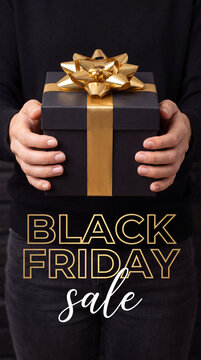 Woman holding a black gift box with a gold ribbon and bow, featuring a promotional text for Black Friday sale in a dark background setting
