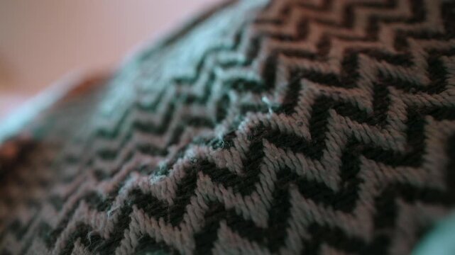 Brown and cream woven textile with repeating geometric pattern, showing thick interlaced yarn, raised stitches and soft fibers across the fabric surface in alternating rows