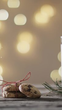 Animation of snowflake christmas decorations, cookies and glass of milk on grey background